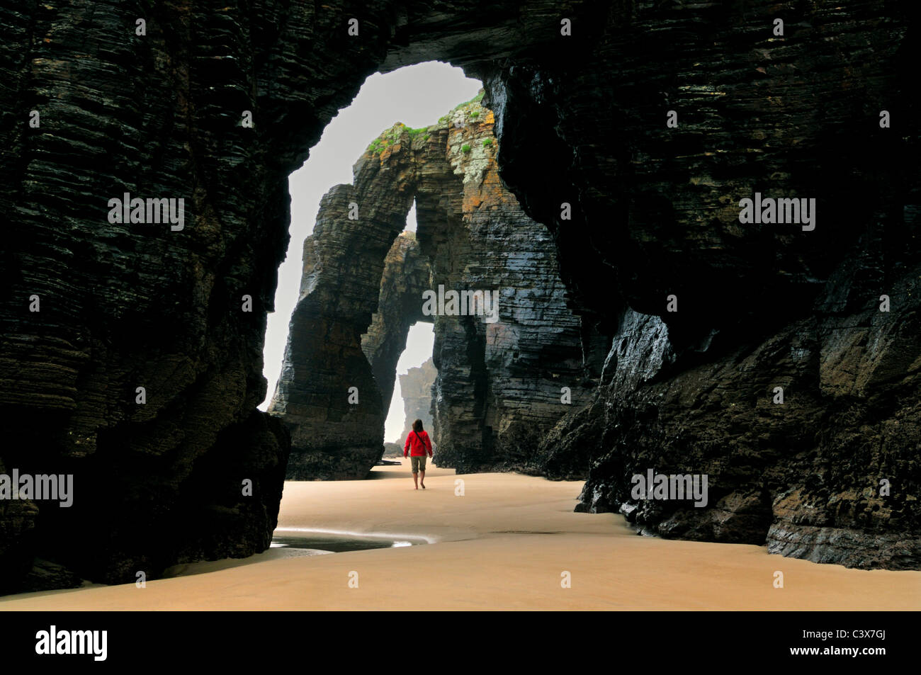 Spanien, Galicien: Frau zu Fuß in den natürlichen Höhlen des Strandes "Praia als Catedrais aufsuchen" Stockfoto