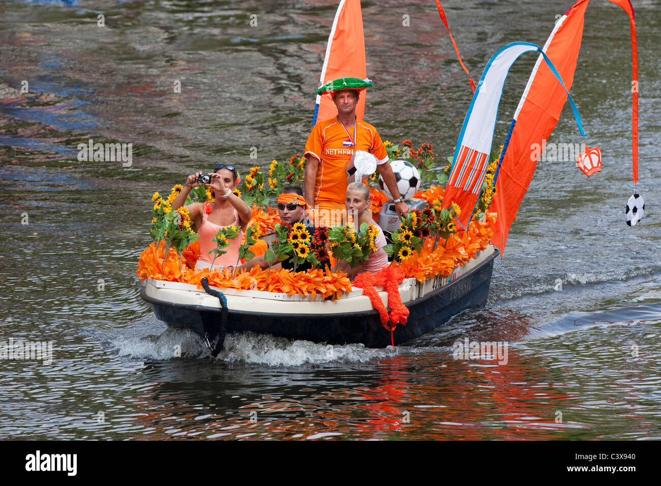Einweihung Kanal-Parade der niederländischen Nationalmannschaft. Boot mit Unterstützern, gekleidet in der nationalen Farbe: Orange.  WC-Footbal 2010. Stockfoto