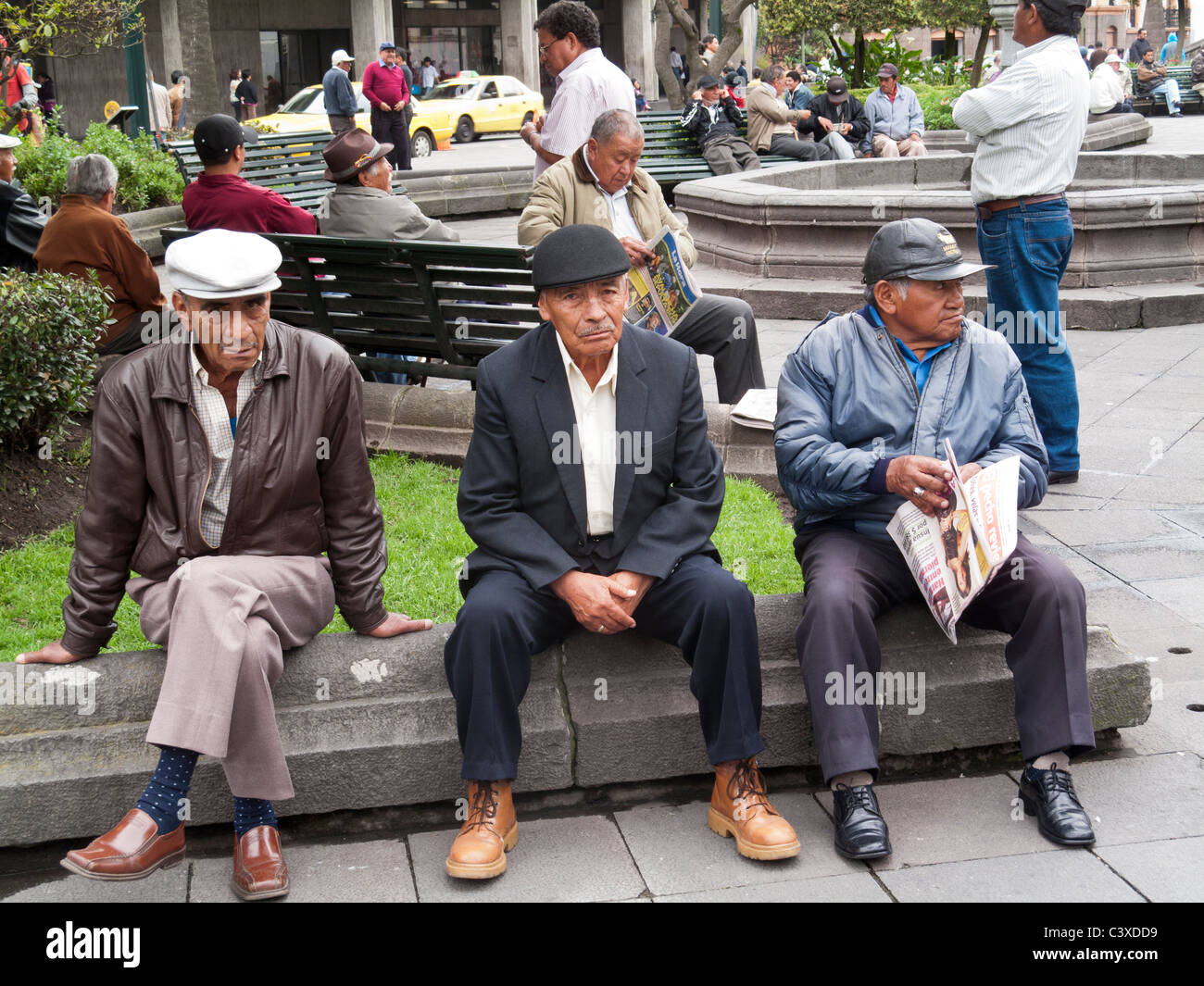 drei Männer sitzen auf einer Bank Plaza Grande, Centro Historico, Quito, Ecuador Stockfoto