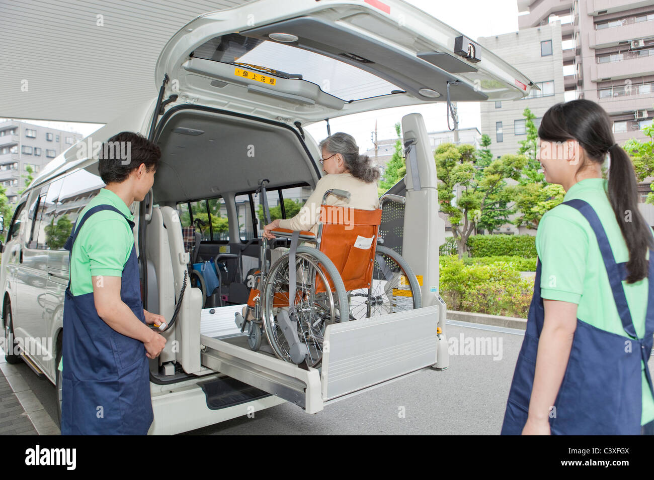 Ältere Frau in Van, zwei Krankenschwestern beobachten Stockfoto