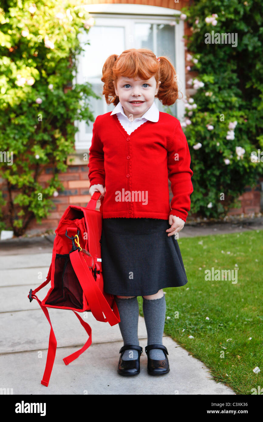 Ein 4 Jahre altes Mädchen mit Ingwer Haare auf ihren ersten Schultag. Stockfoto