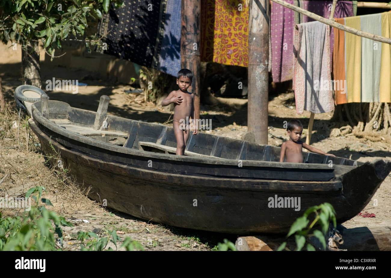 Jungen spielen auf einem Boot am Ufer. Stockfoto