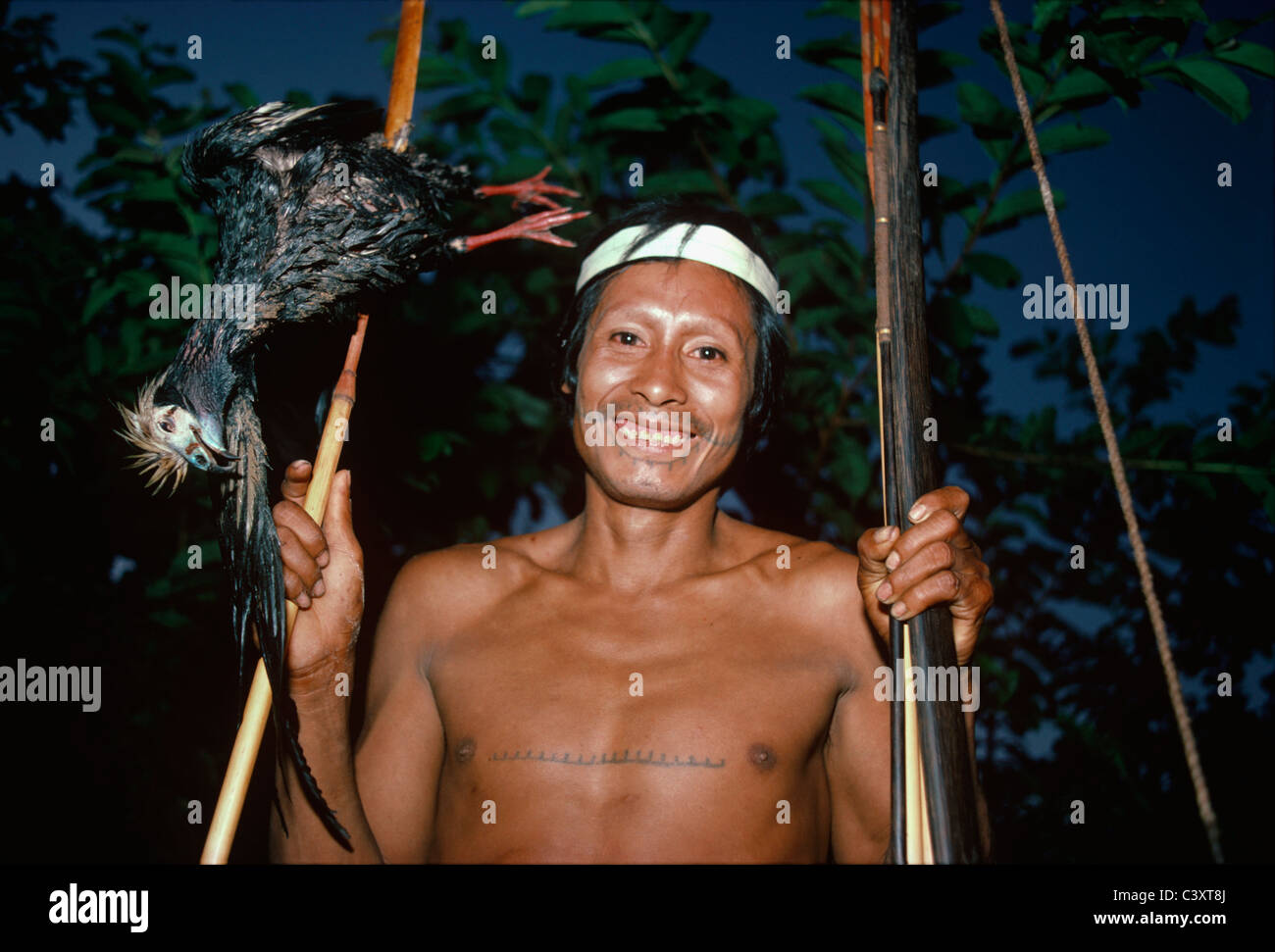 Matses Stammesangehörige mit einer Ente (Rohrleitungen Guan) aus dem Amazonasgebiet mit seinem Pfeil und Bogen getötet. Matses Indianer. Amazonas, Peru. Stockfoto