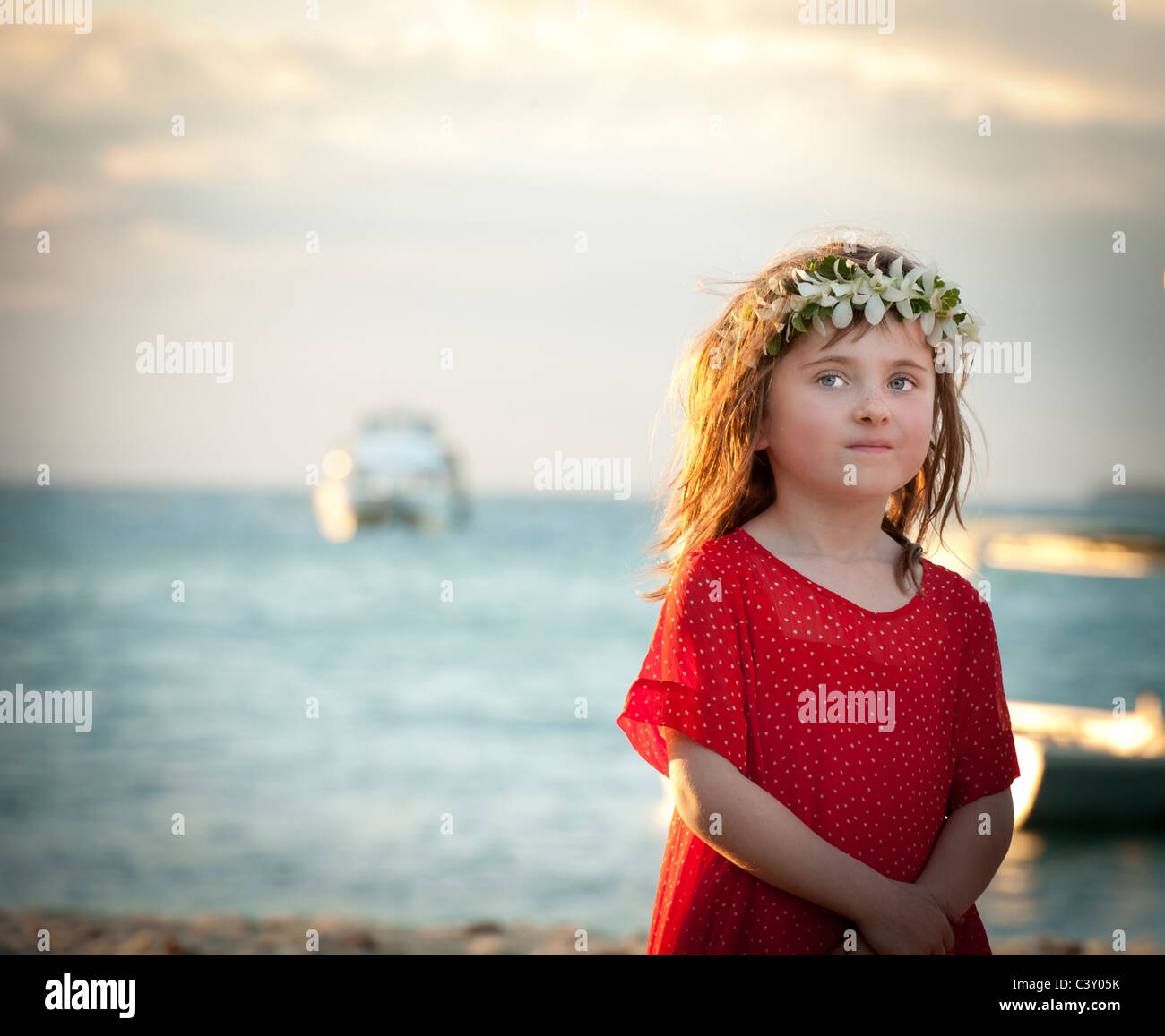 kleines Mädchen mit Blumen in ihrem Haar und roten Kleid Blick unschuldig  aus in Ferne Stockfotografie - Alamy