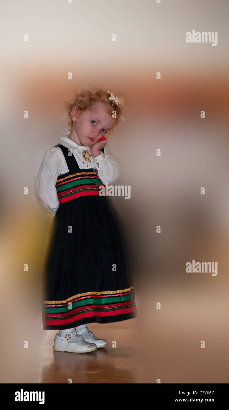 Dieses hübsche junge Kleinkind Mädchen ist einen Norwegische Tracht tragen. Ihre niedlichen kurzen, lockigen blonden Haaren und blauen Augen. Stockfoto