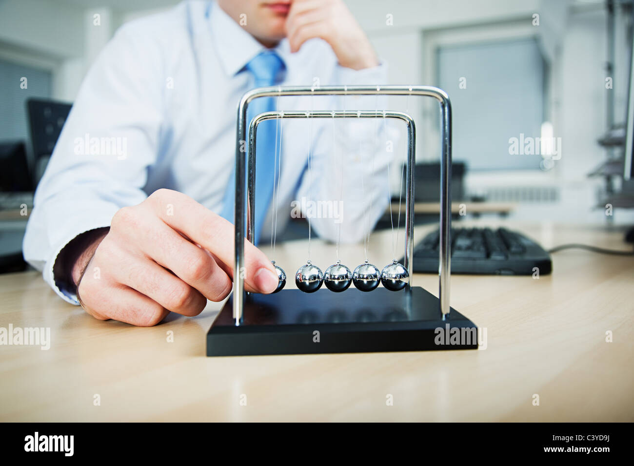 Büroangestellte mit Newton-Wiege spielen Stockfoto