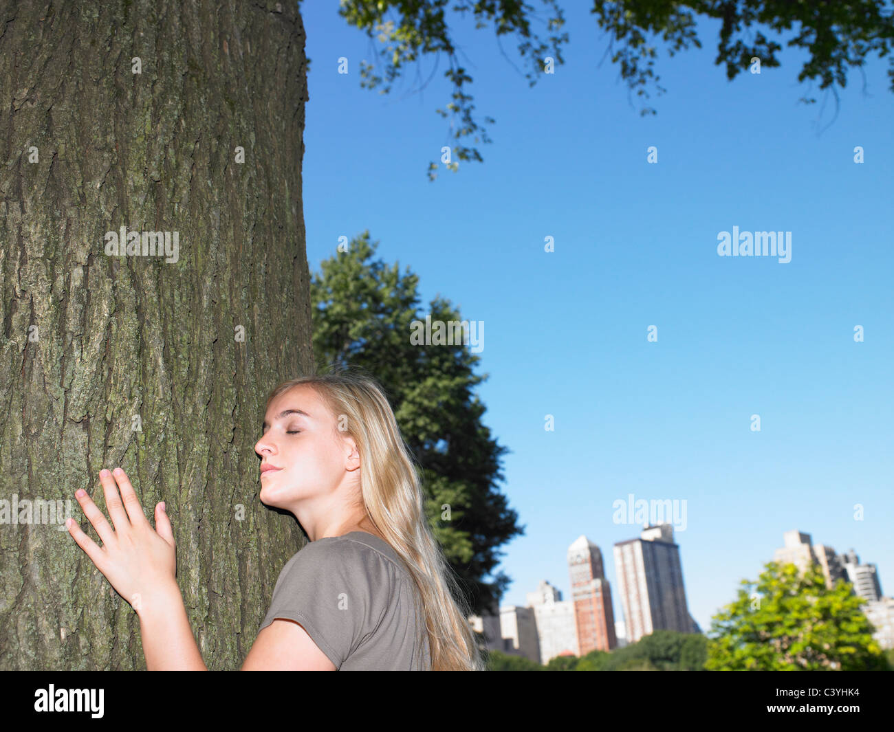 Frau umarmt einen Baum Stockfoto