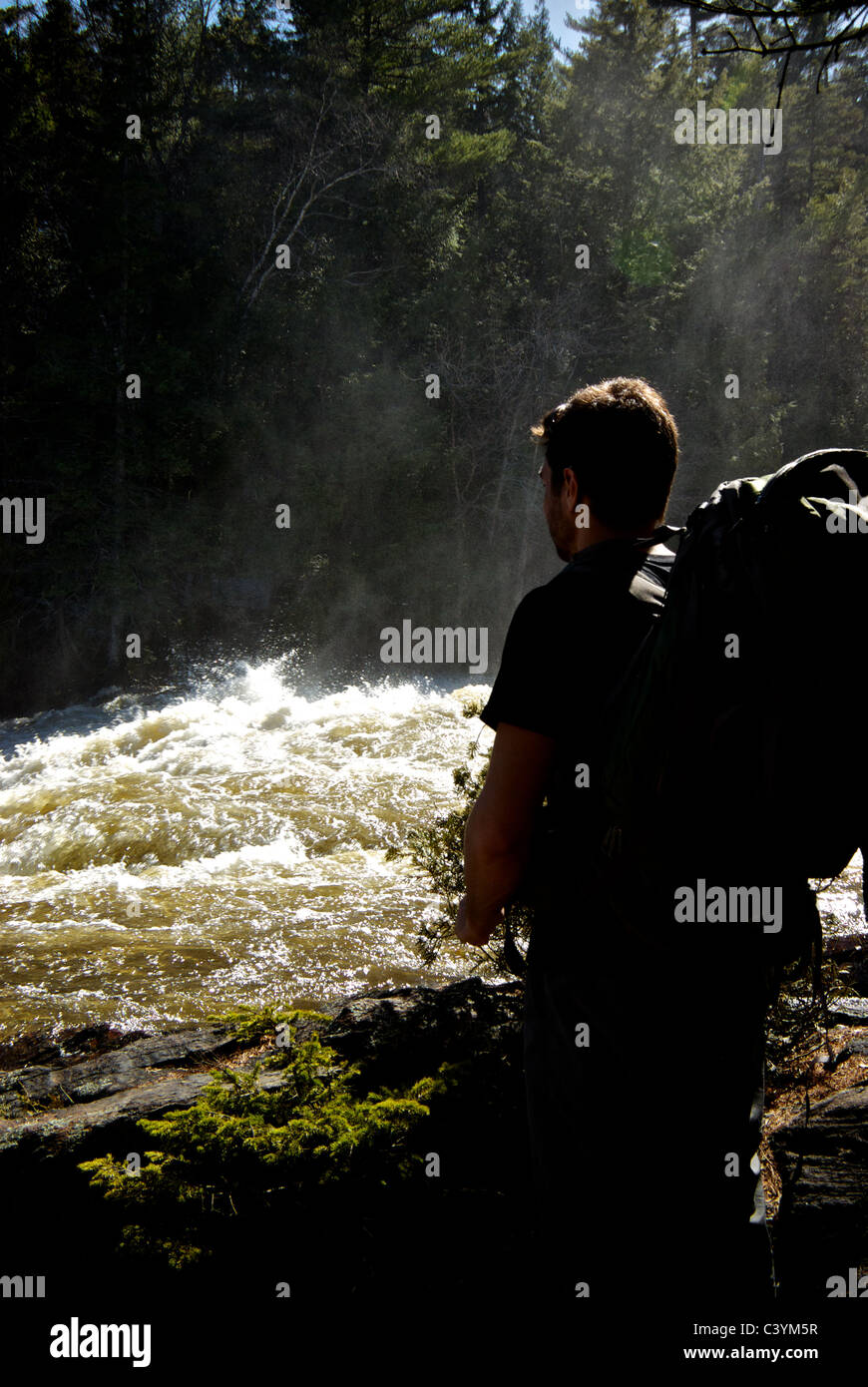 Wanderer, die tobenden Rivière-du-Loup betrachten, während volle Frühjahr Hochwasser Kaskadierung über Le Rutsche Aux zittert Wasserfall Stockfoto