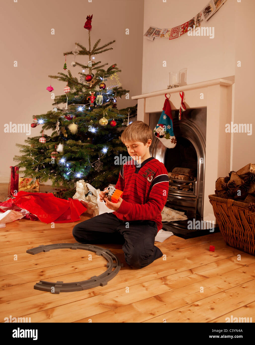 Ein kleiner Junge spielt mit einer Spielzeugeisenbahn Stockfoto