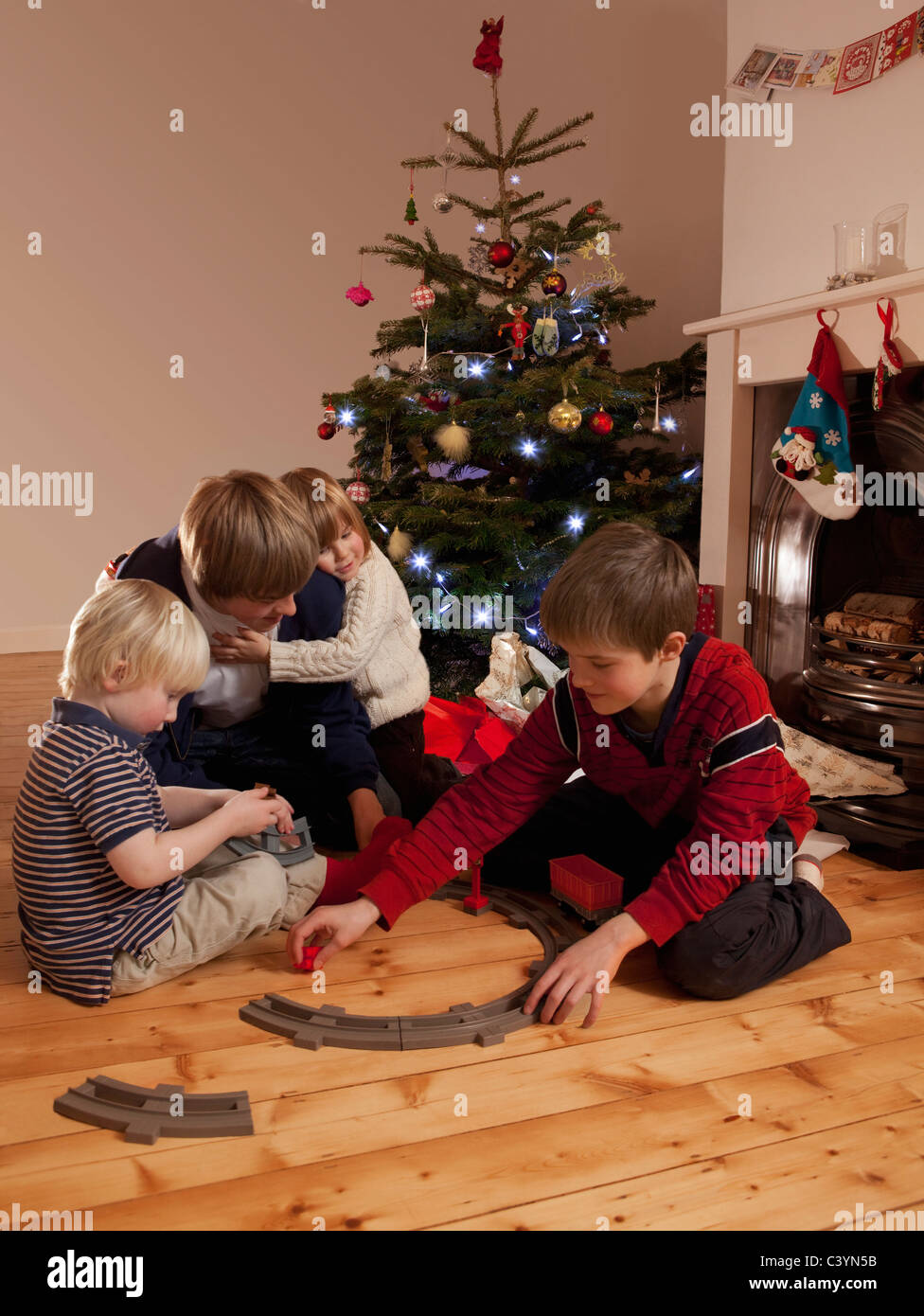 Vier Jungs spielen mit einem Zug-set Stockfoto