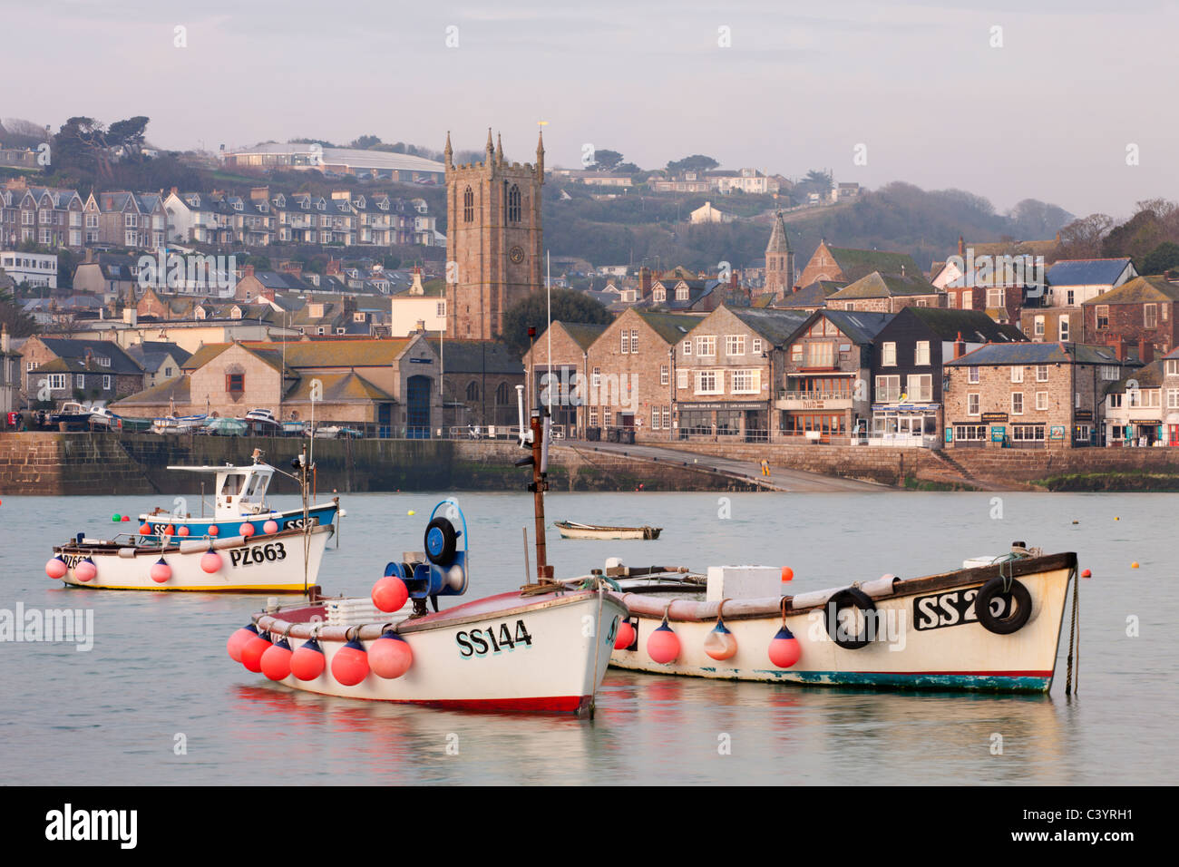 Angelboote/Fischerboote, Geschäfte, Häuser und Kirche blicken auf den malerischen Hafen von St. Ives, Cornwall, England. Frühling 2011 (März). Stockfoto