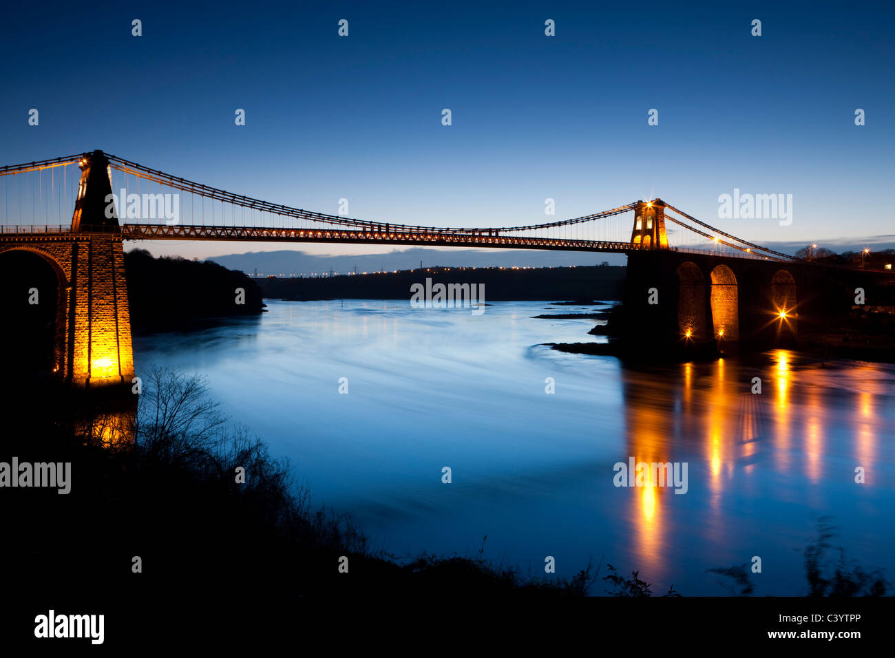 Am Abend Beleuchtungen auf die Menai-Brücke über die Menai Strait, Anglesey, North Wales, UK. Frühling (April) 2011. Stockfoto