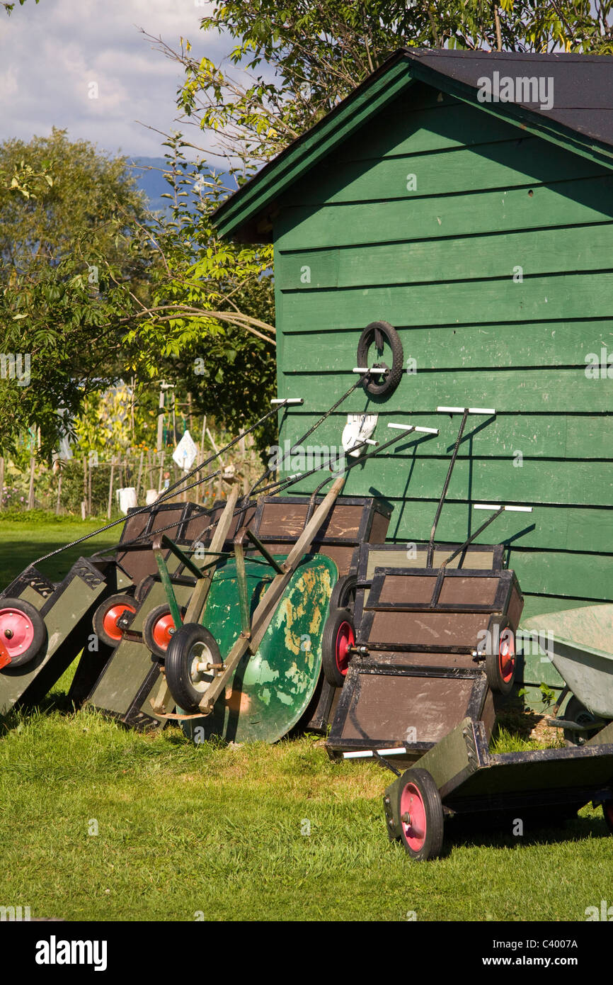 Verschiedenen Schubkarren und Karren lehnen an einem Schuppen in einen gemeinschaftlichen Garten, Kolonie Farm Regional Park, Port Coquitlam, BC, Kanada Stockfoto