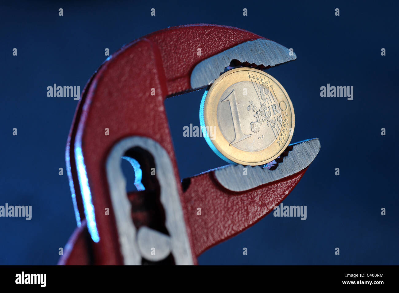 1-Euro-Münze in einen verstellbaren Schraubenschlüssel Stockfoto