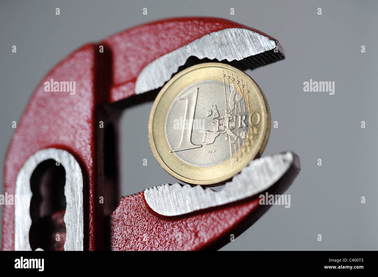 1-Euro-Münze in einen verstellbaren Schraubenschlüssel Stockfoto