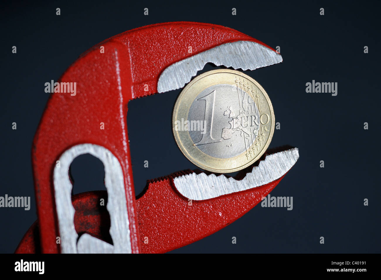 1-Euro-Münze in einen verstellbaren Schraubenschlüssel Stockfoto