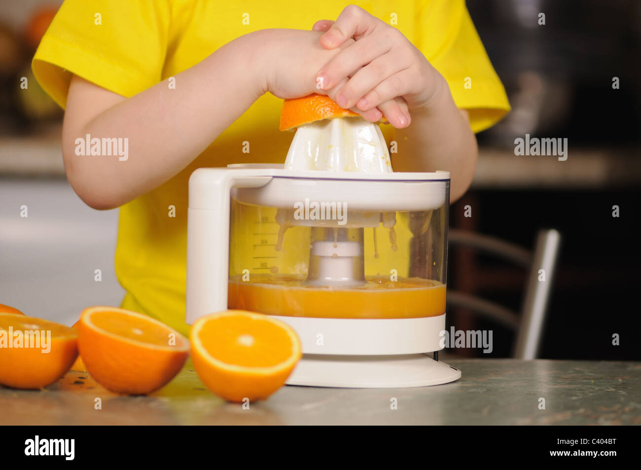 Das Kind in eine gelbe Weste, auswringen, Saft von einer orange Stockfoto