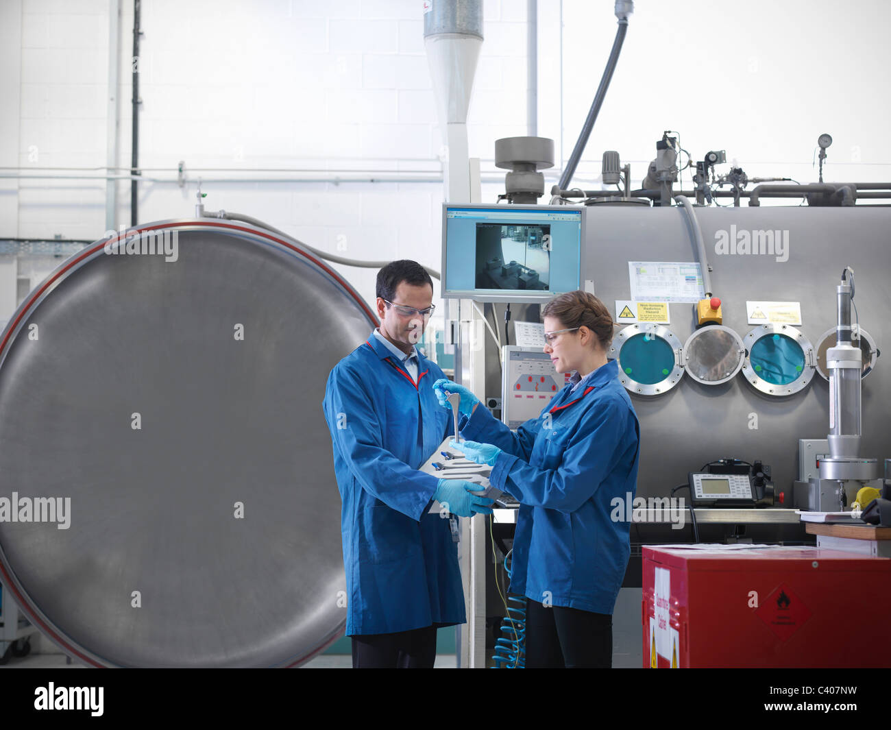 Wissenschaftler mit Produkt- und Vakuum-tank Stockfoto