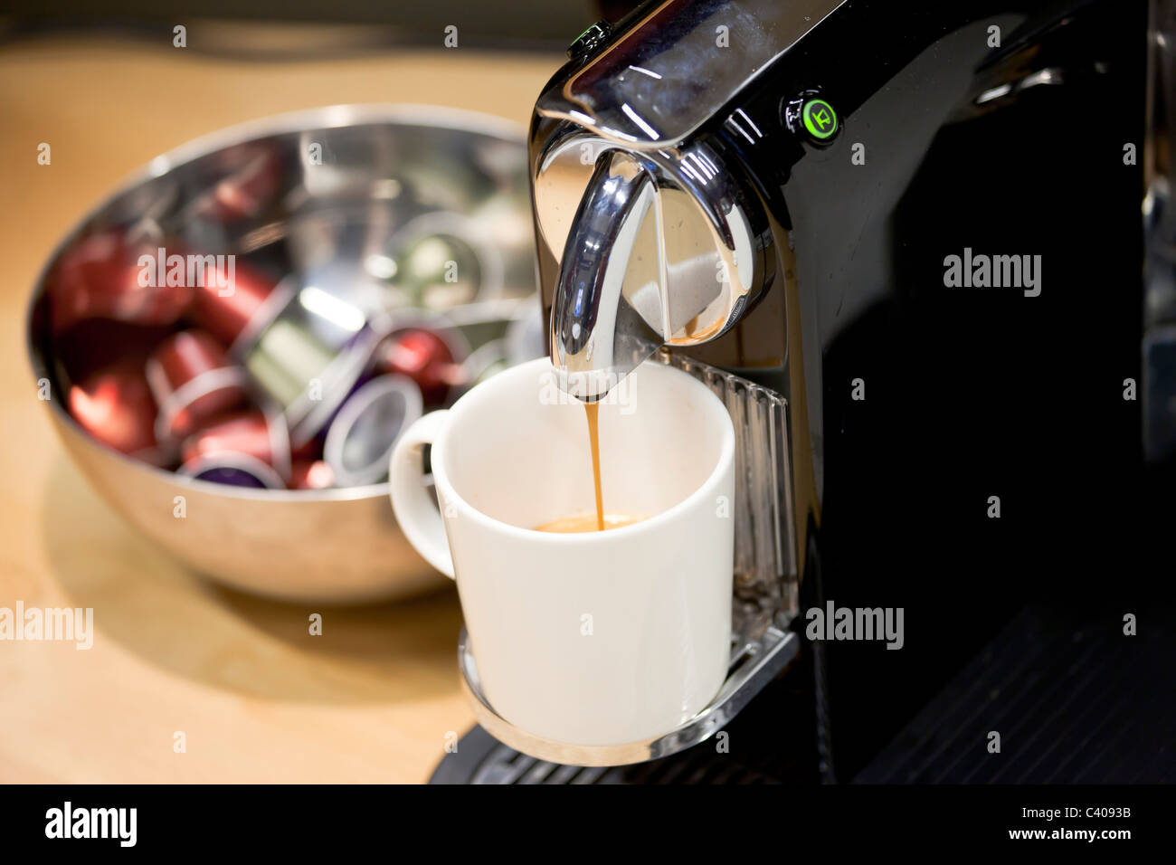 Nahaufnahme von Nespresso Kaffeemaschine frisch neue Espresso brauen. Kaffee Kapseln in einer Schüssel im Hintergrund Stockfoto