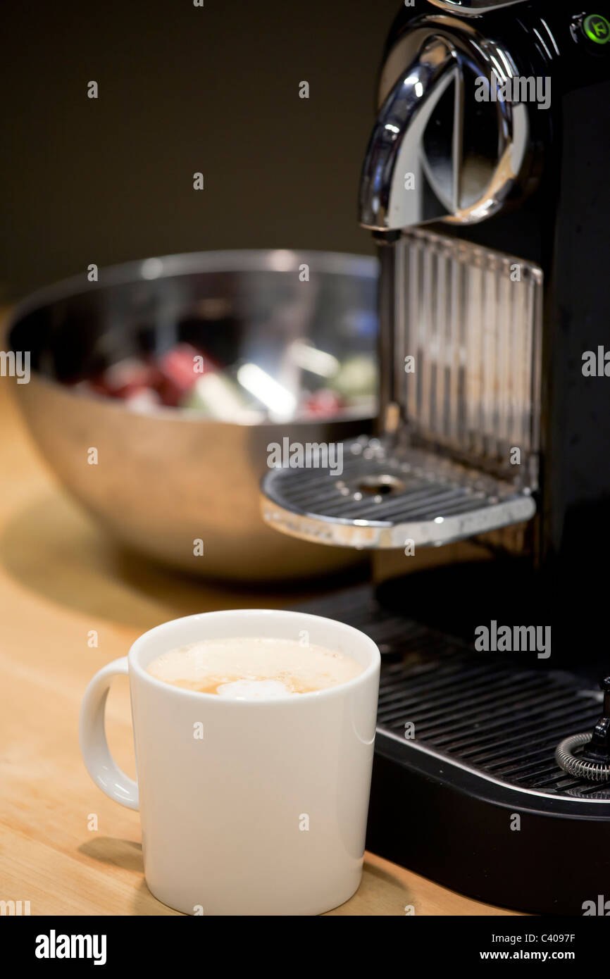Nahaufnahme von Nespresso Kaffeemaschine frisch neue Espresso brauen. Kaffee Kapseln in einer Schüssel im Hintergrund Stockfoto