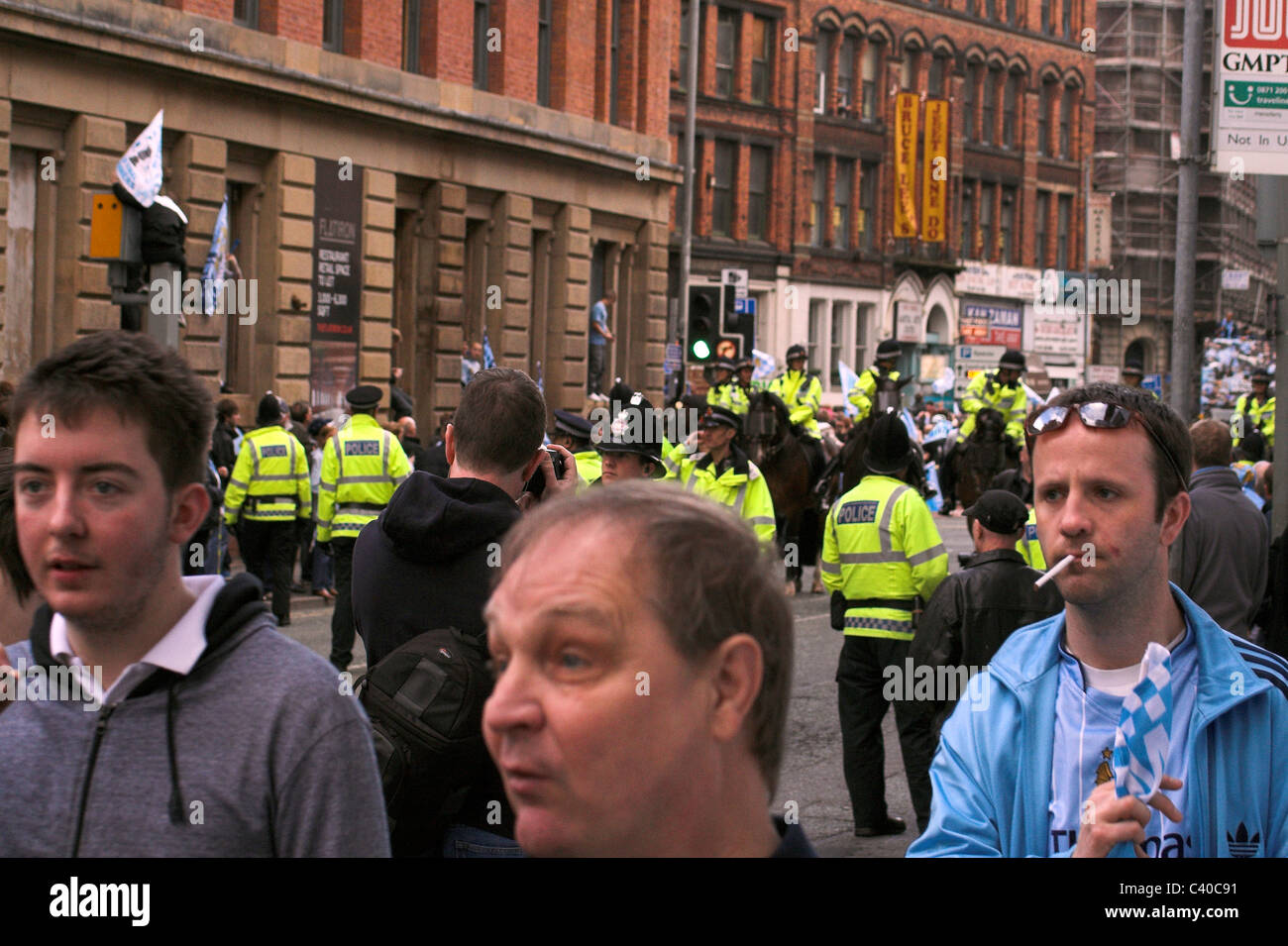 Fans und Polizei sammeln entlang Newton Street für die Manchester City Cup Parade 2011 Stockfoto