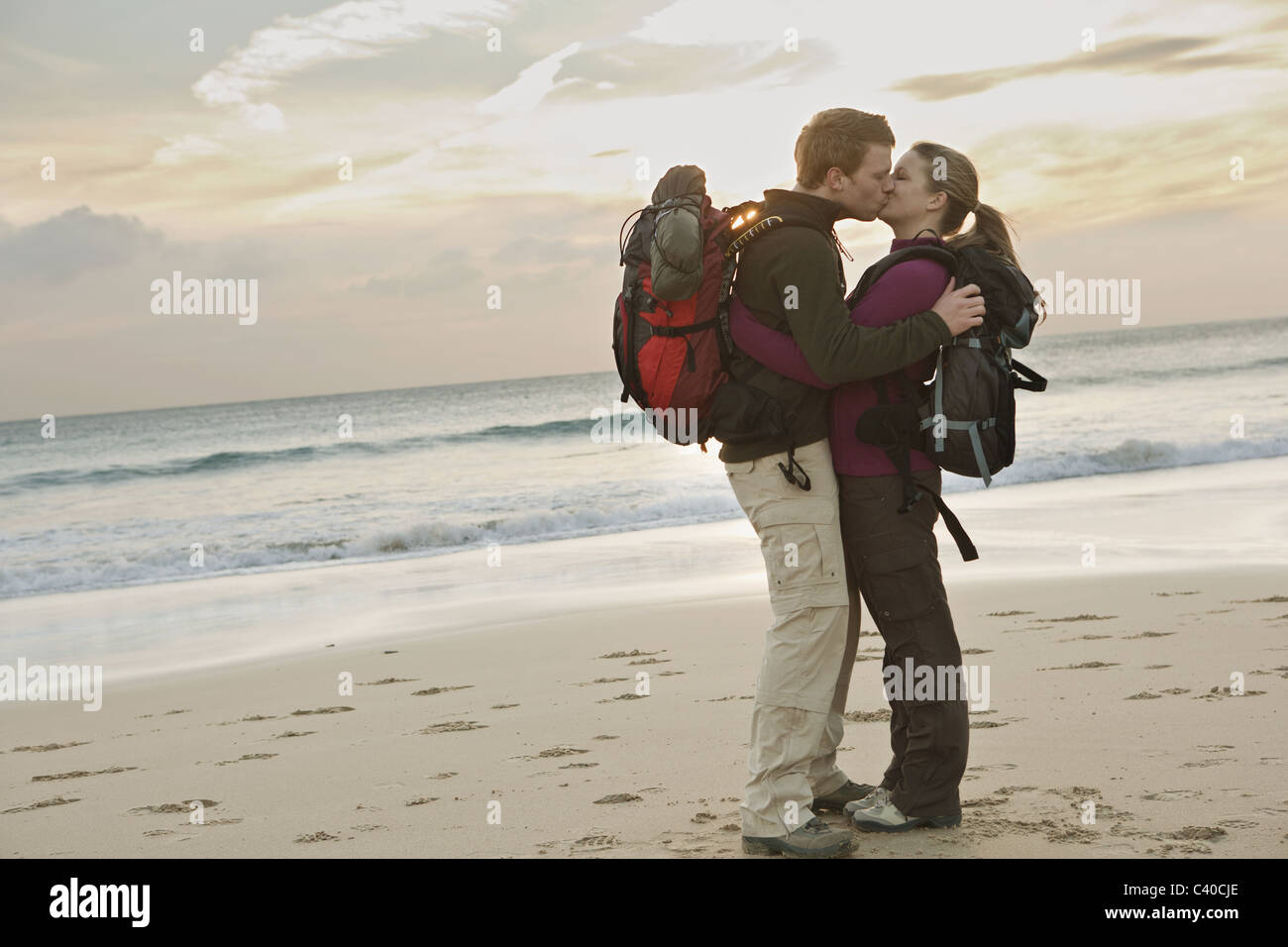 Rucksackreisen paar küssen am Strand Stockfoto