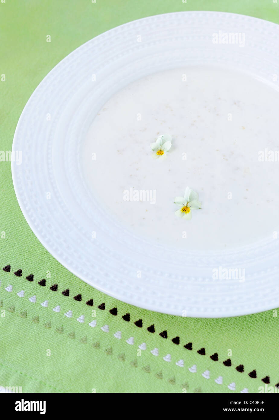 Haferflocken-Porridge mit Veilchen auf einer Olive Serviette verziert. Stockfoto