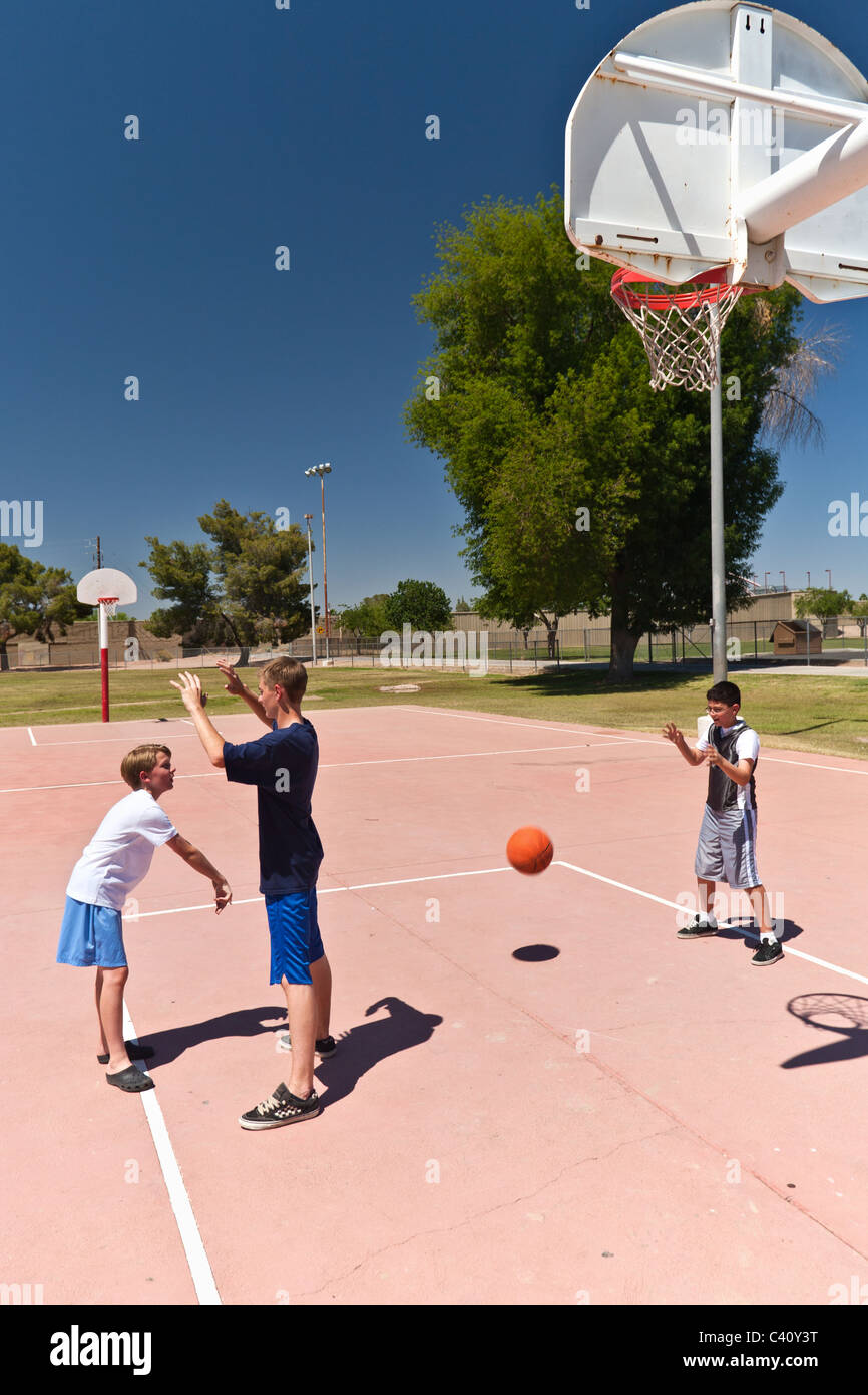 Jungen spielen Basketball auf ein Outdoor-Stadtteilpark Stockfoto