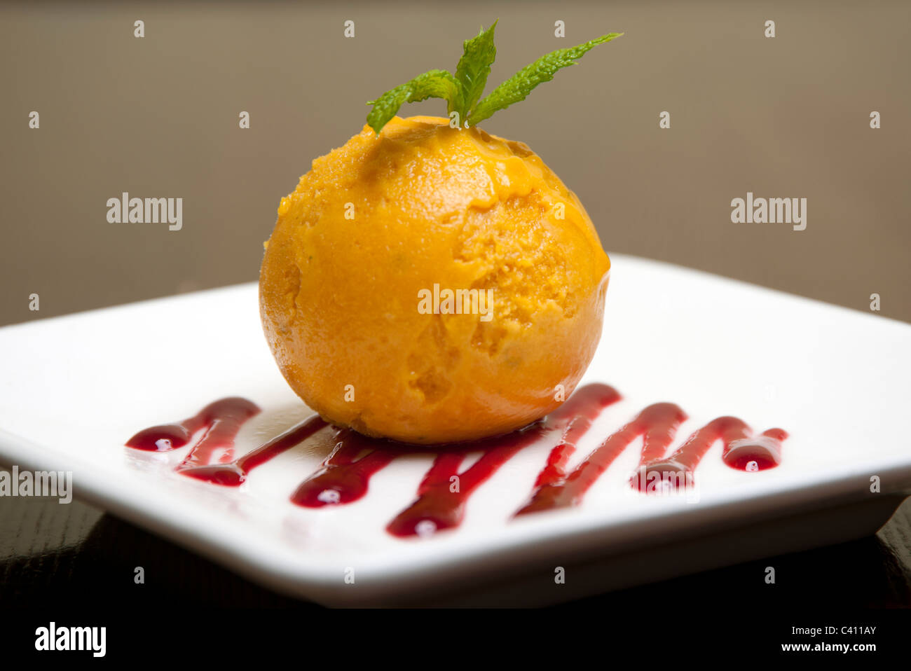 Kugel Mangosorbet auf einem Teller Stockfoto