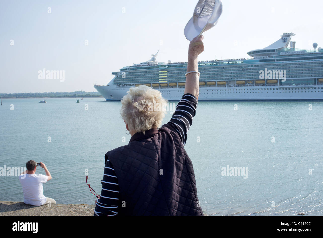 Frau winken wie die Unabhängigkeit der Meere Kreuzfahrtschiff fährt von Southampton docks Stockfoto