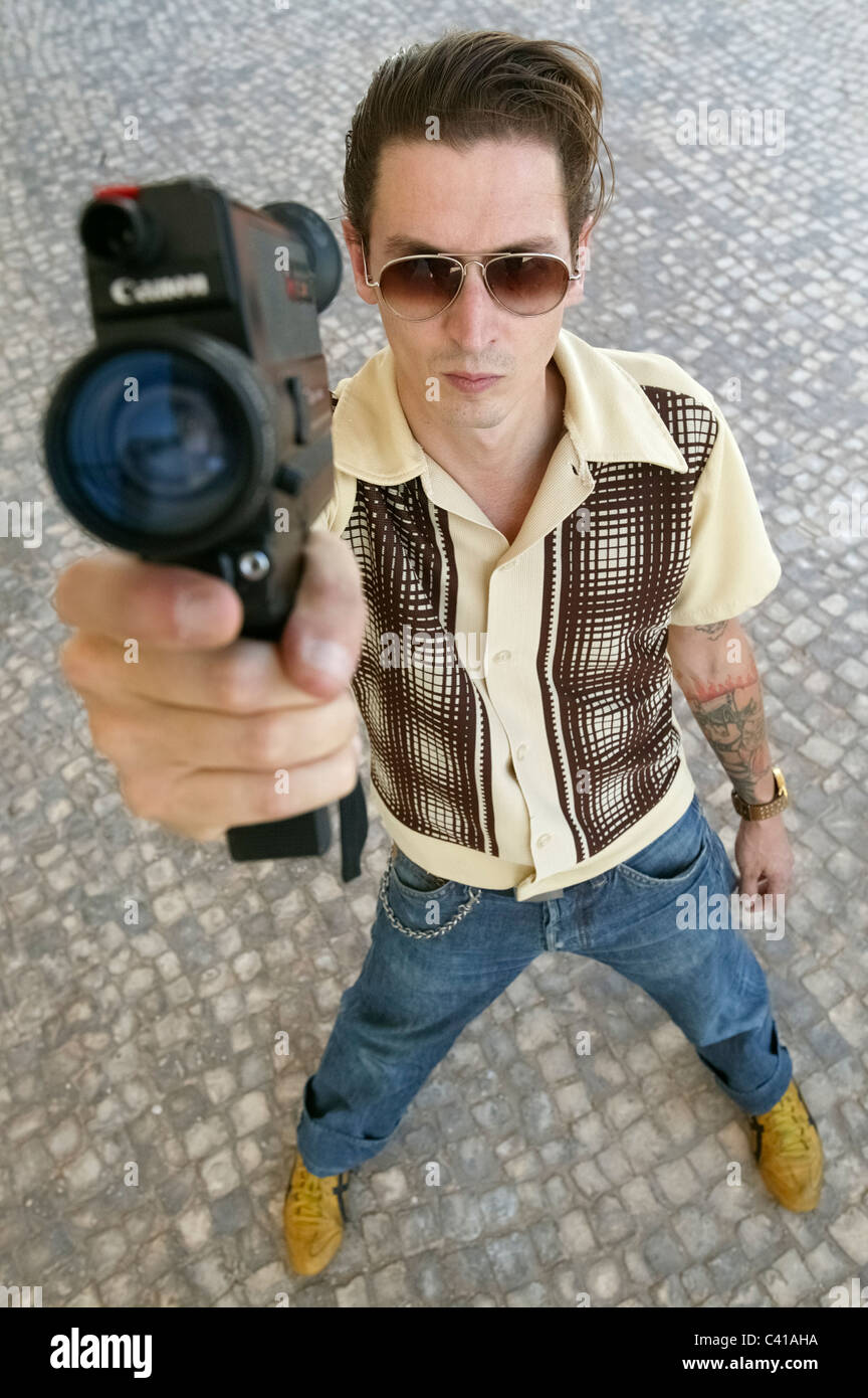 Mann, der alte Canon Super8-Kamera hält Stockfoto