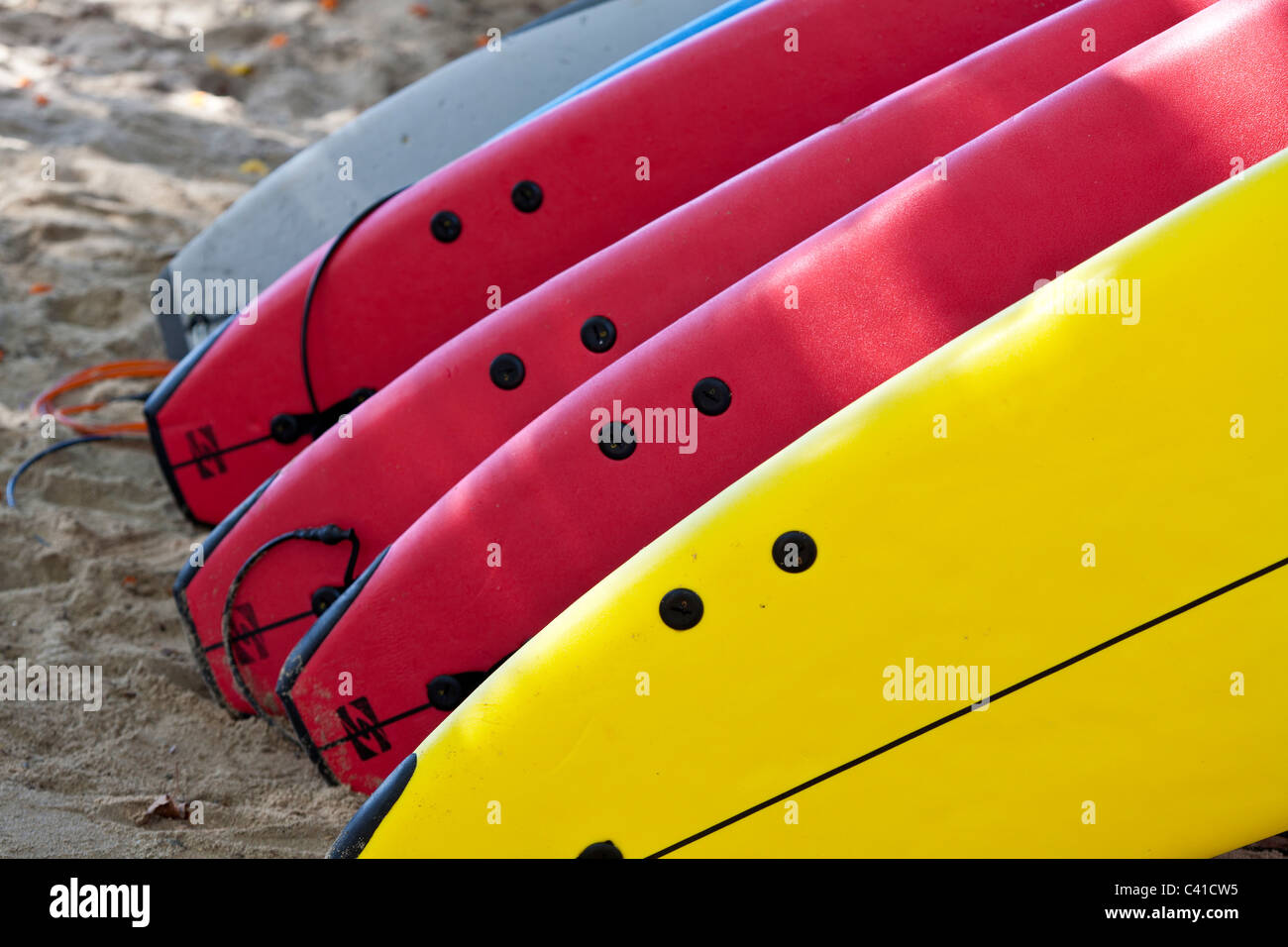 Bereit für die Brandung: Vermietung Surfbretter gestapelt am Waikiki Beach. Eine Sammlung von roten und gelben Surfbretter erwarten Mieter Stockfoto