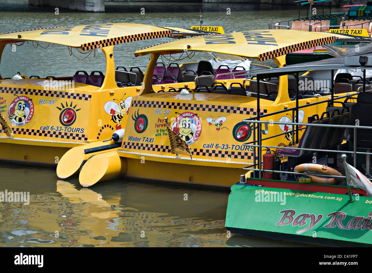Gelbe und grüne Wasser Taxi Boote vor Anker auf dem Singapore River in der Nähe von Clarke Quay Republik von Singapur Asien Stockfoto