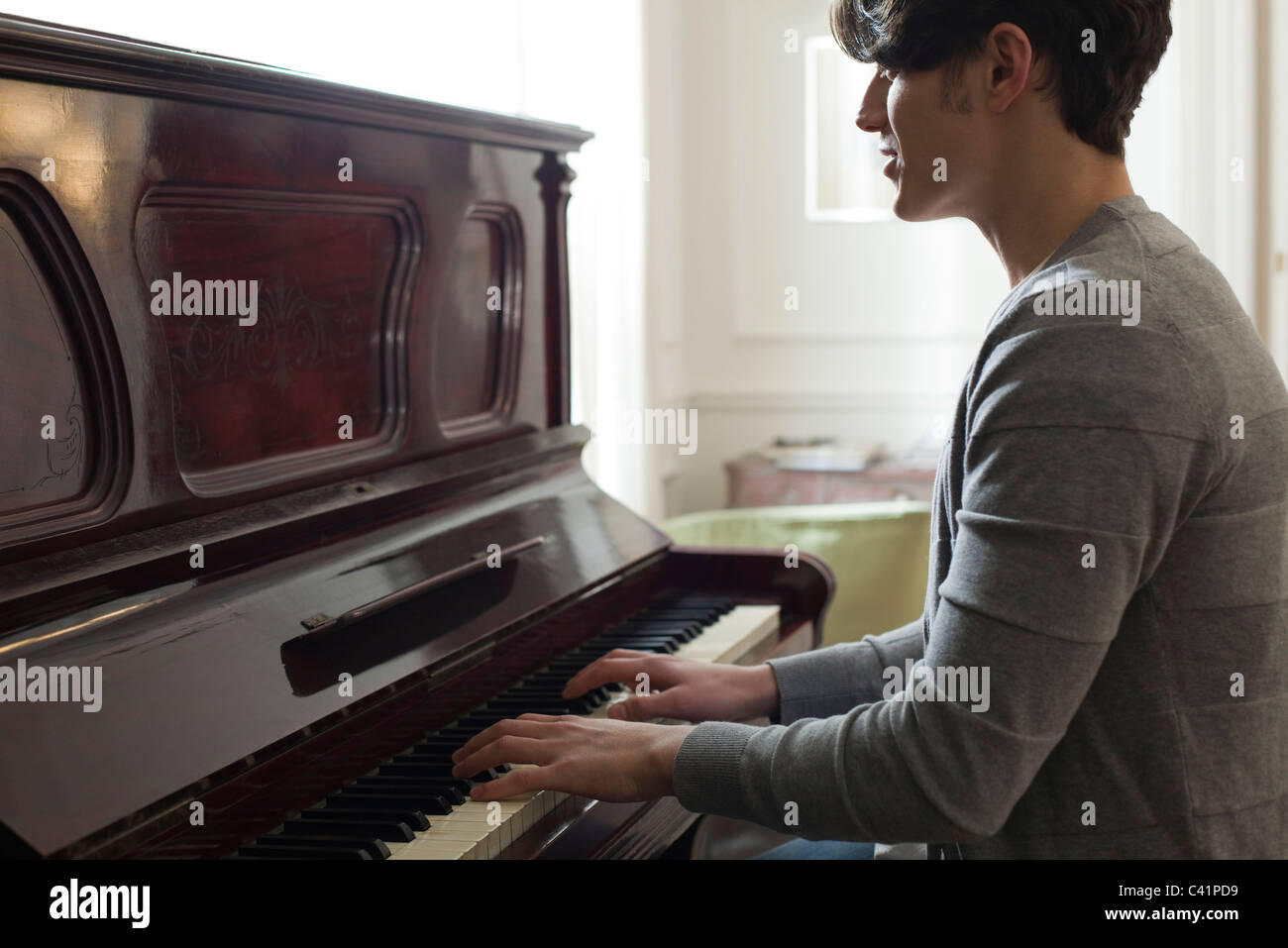 Junger Mann spielt Klavier Stockfoto