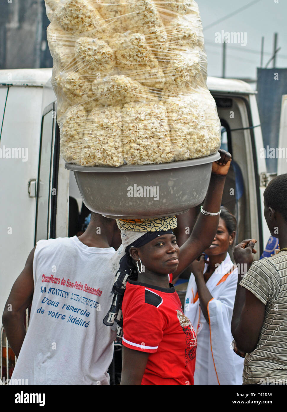 Frau verkauft Popcorn an einer Bushaltestelle in Abidjan, Elfenbeinküste Stockfoto