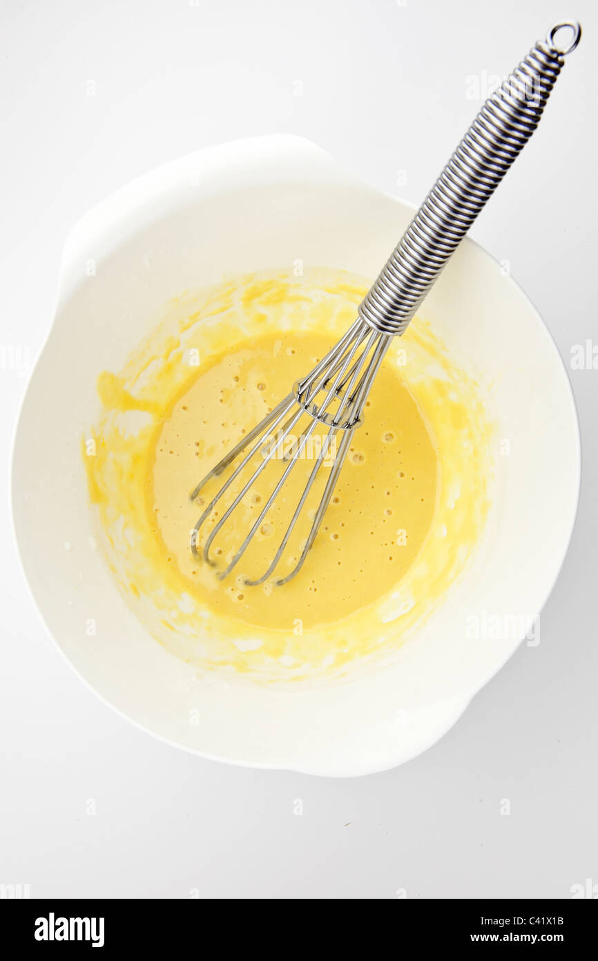 flüssiger Teig für Kekse in einer weißen Schüssel mit Schneebesen Stockfoto