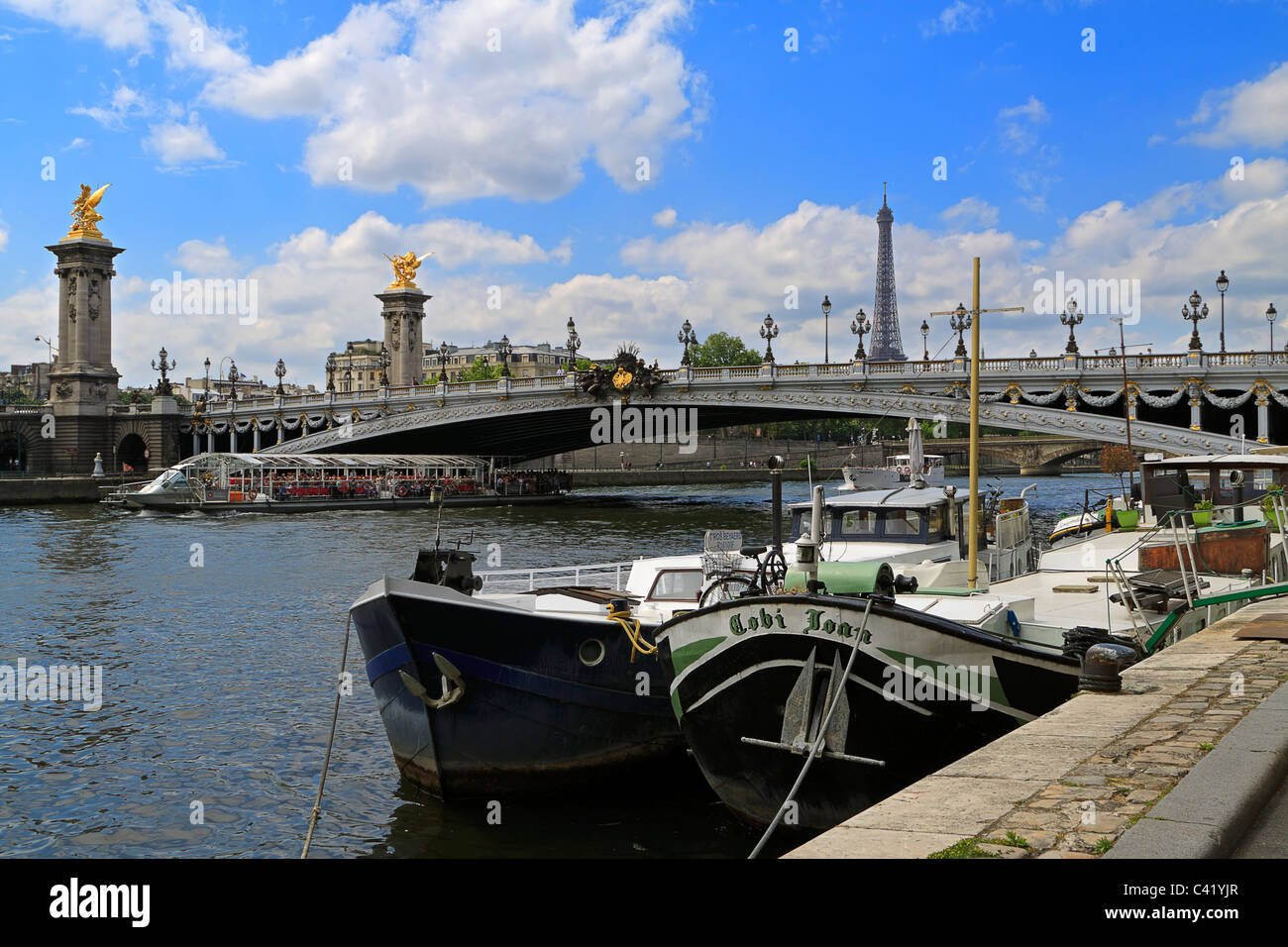 Hausboote auf der Seine mit dem Pont Alexandre III und den Eiffelturm im Hintergrund Stockfoto