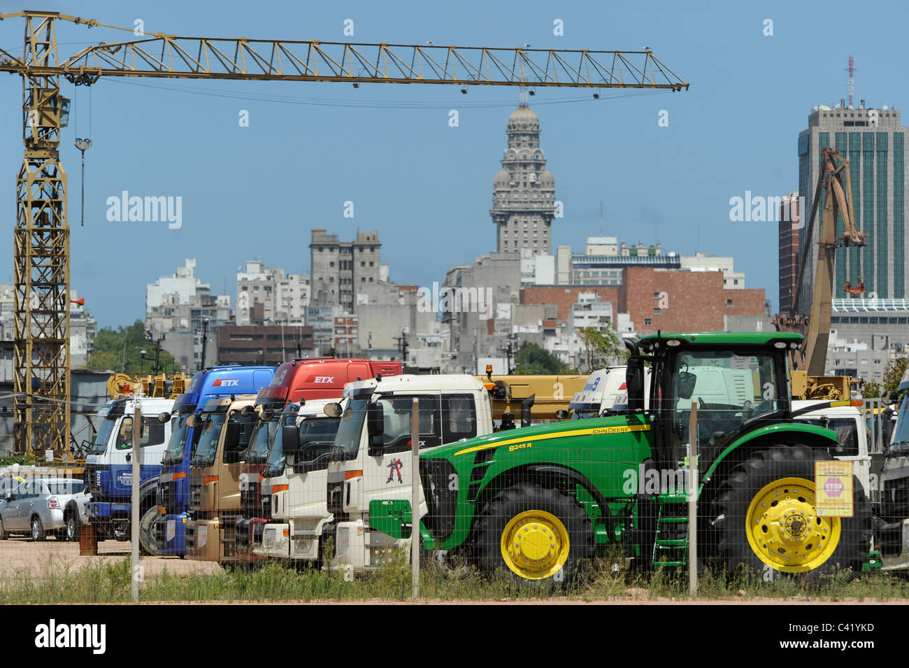 URUGUAY Montevideo Blick vom Hafen zur Stadt und das hohe Gebäude Palacio Salvo, vorne Importfahrzeuge John Deere Traktor Stockfoto