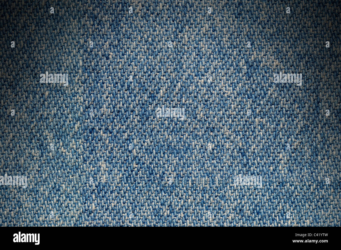 Blue-Denim Stoff Textilhintergrund beleuchtete dramatisch von oben Stockfoto