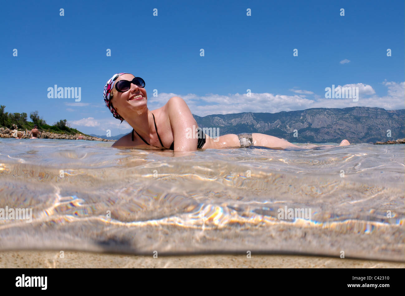 Split Level, Frau Solarium im Wasser, liegend Leopatra Insel (Cedar), Ägäis, Türkei Stockfoto