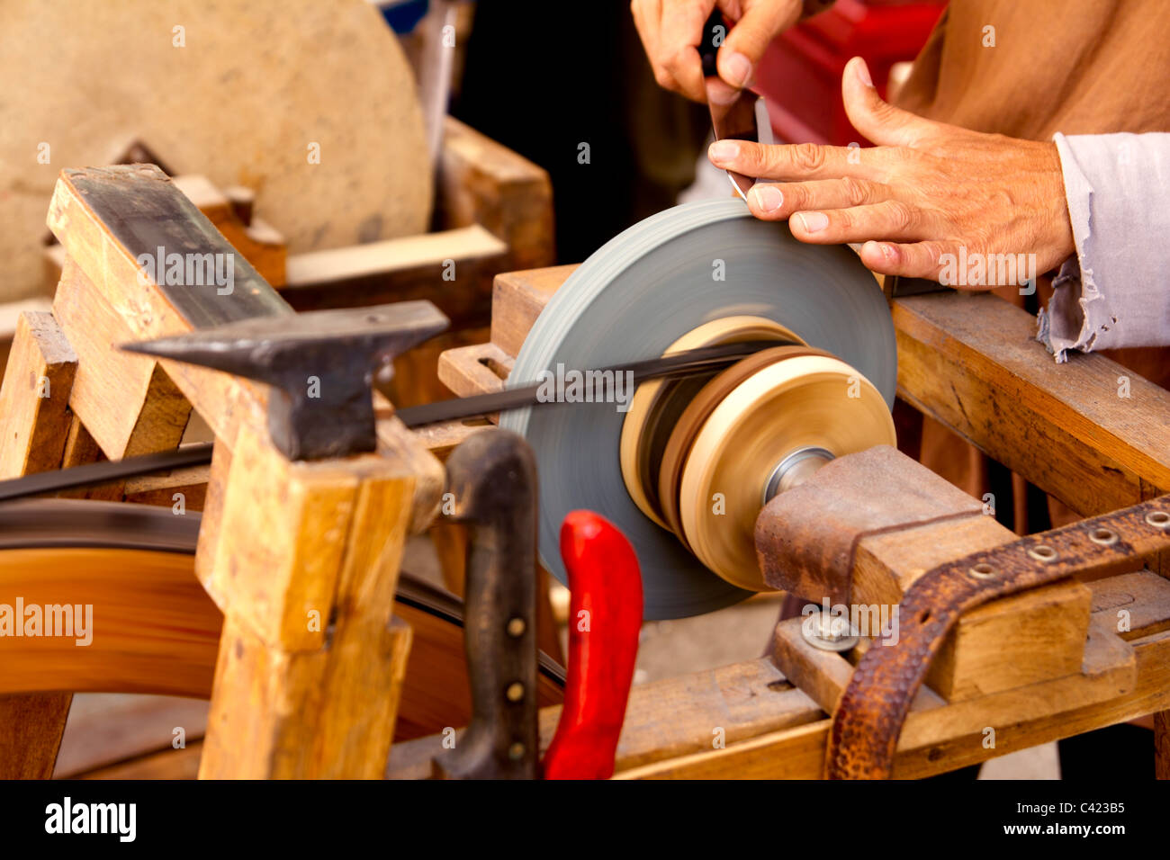 Schleifer traditionellen Rad-Handwerkzeuge schärfen Messer Hände Stockfoto