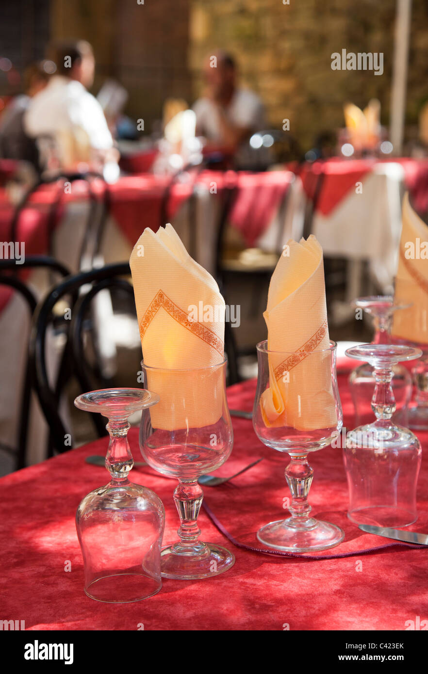 Gläser mit Servietten in gedeckten Tisch mit Menschen im Hintergrund Restaurant Sarlat-la-Caneda Dordogne Frankreich Stockfoto