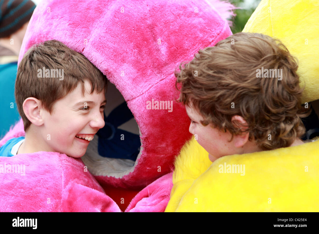 Zwei jungen lachen, wie sie auf die Köpfe der flauschigen Enten in den Paisley-Entenrennen Stockfoto