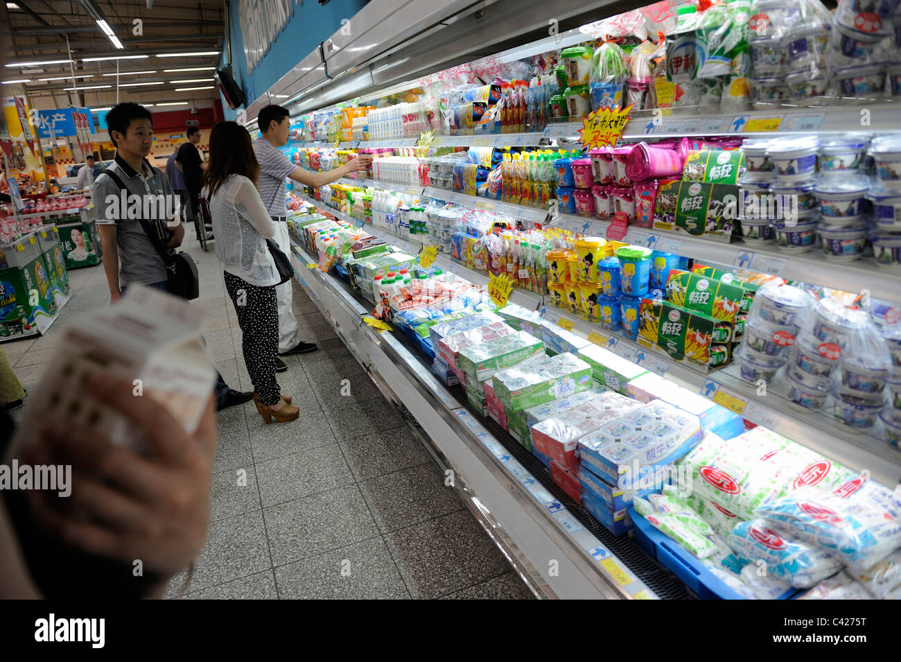 Chinesische Kunden kaufen Milchprodukte in einem Wumart Supermarkt in Peking, China. 28. Mai 2011 Stockfoto