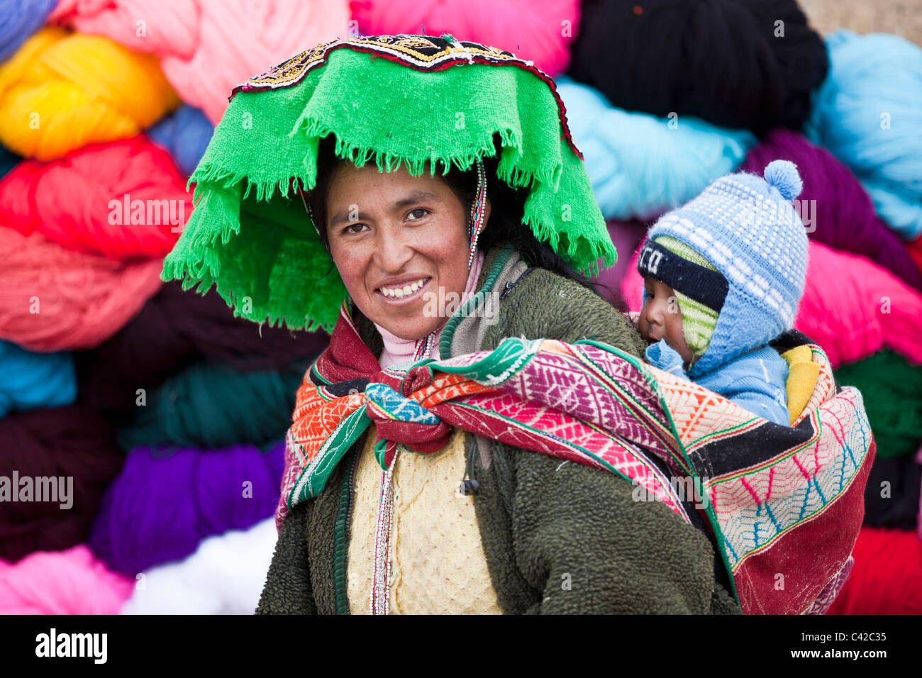 Peru, Huancarani, Frau und Kind vor Wolle zum Verkauf auf Markt. Stockfoto