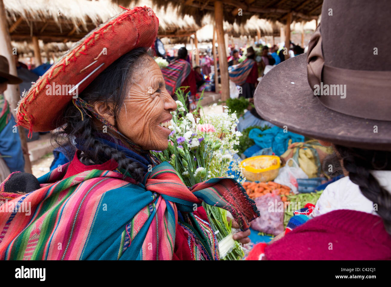 Peru, Chinchero, Frauen am Markt verkaufen und kaufen, Obst, Blumen und Gemüse. Stockfoto