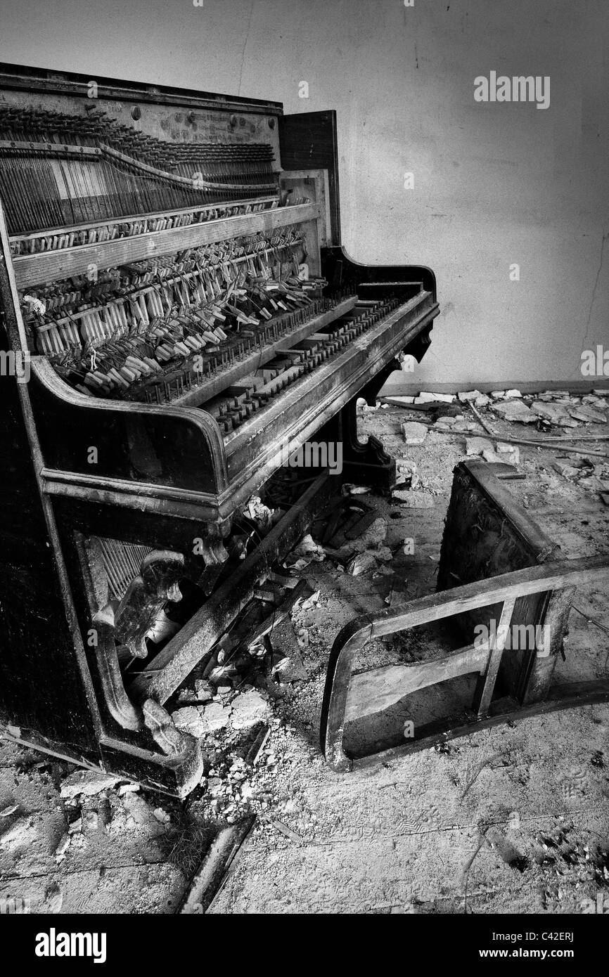 altes Klavier in gefallenen Haus links Stockfoto