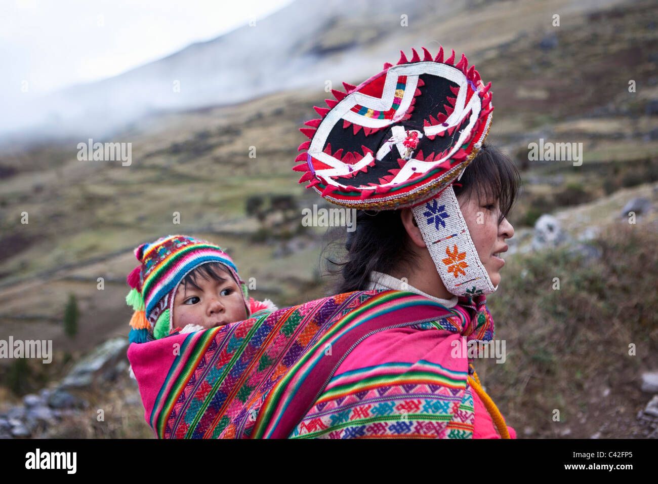 Peru, Patakancha, Patacancha, Dorf in der Nähe von Ollantaytambo. Indischen Baby in traditioneller Tracht auf Mutters Rücken. Stockfoto