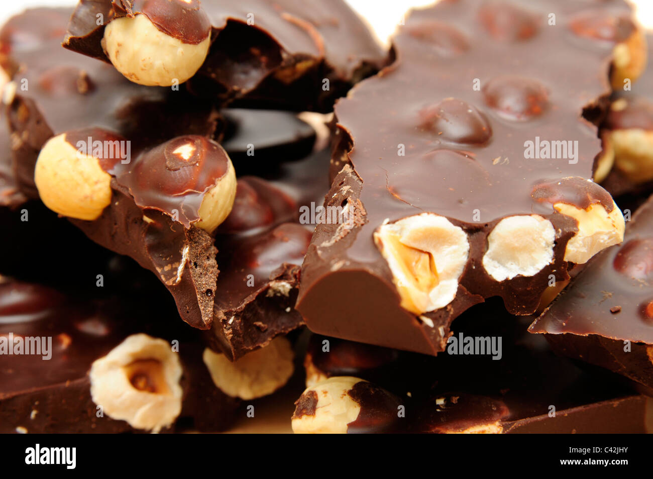 Schokolade mit Nüssen auf dem weißen Hintergrund isoliert. Stockfoto