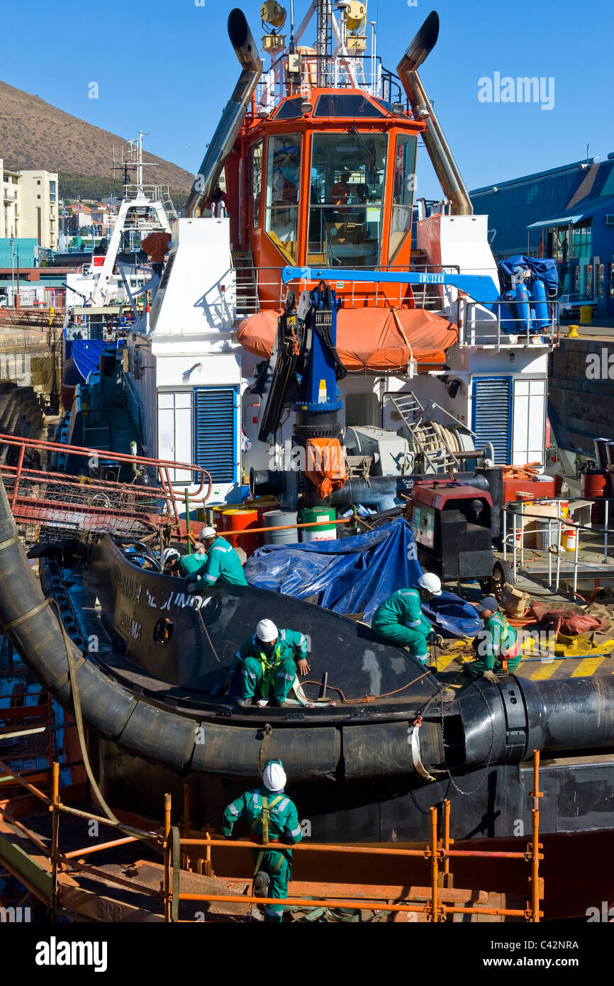 Arbeitnehmer, die Reparatur von einem Schlepper in einem trockenen dock in Cape Town, South Africa Stockfoto